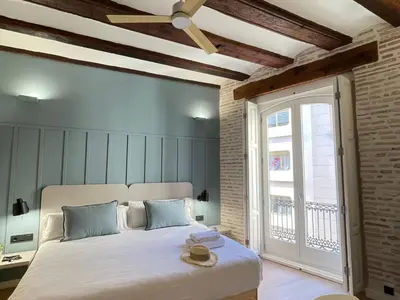a bedroom with a bed with a ceiling fan at Cosy Rooms Embajador in Valencia