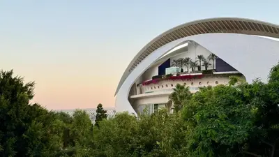 a building with palm trees in front of it at Cosy Rooms Embajador in Valencia