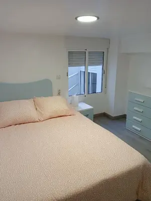 a bedroom with a large bed and a window at Apartamento Luminoso cerca de la PLAYA y PUERTO in Valencia