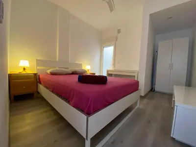 a bedroom with a large bed with a pink blanket at Casa Quintero Valencia Playa Cabañal in Valencia