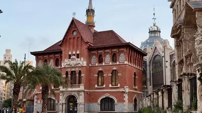 a large red brick building with a tower at Cosy Rooms Bolsería in Valencia
