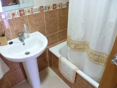 a bathroom with a sink and a shower with a shower curtain at Hetesa 2000, 3º-7 in Cullera