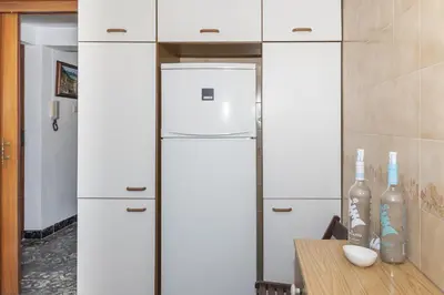 a kitchen with white cabinets and a refrigerator at EL RACO- C, 8-16 in Cullera