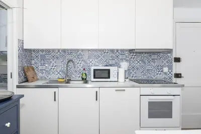 a kitchen with white cabinets and a sink and a microwave at Europa A- 12º-23 in Cullera