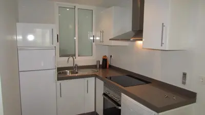 a kitchen with white cabinets and a sink at Casa Cosy in Valencia