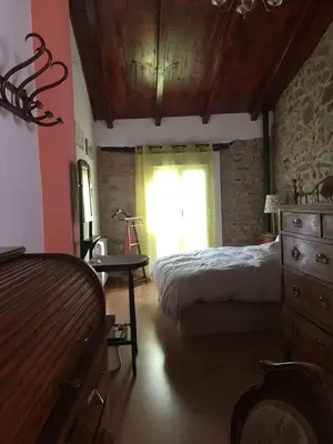 a bedroom with a bed and a dresser and a window at Ca'ls avis in Serra