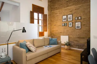 a living room with a couch and a brick wall at SingularStays Quevedo in Valencia