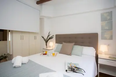 a bedroom with a large white bed and a desk at SingularStays Quevedo in Valencia