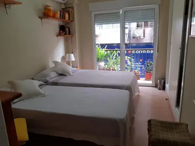 two beds in a room with a window at Habitación privada a 1500 metros de la playa in Valencia