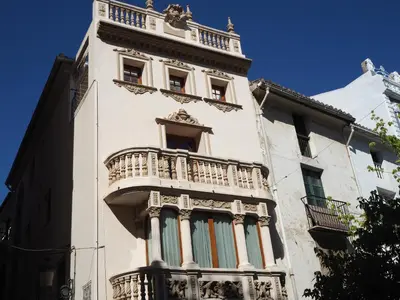 a tall white building with a balcony on it at Varone in Requena