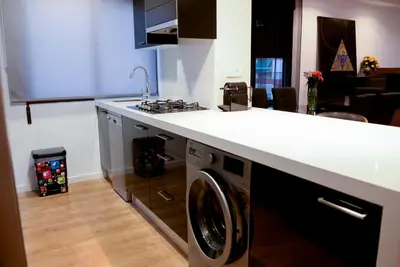 a kitchen with a washing machine under a counter at Piso en La Ciudad de Artes in Valencia