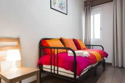 a bedroom with a bed with colorful pillows on it at Your home at Valencia, Cabañal in Valencia