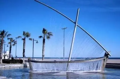 a boat sitting in the water near the beach at Your home at Valencia, Cabañal in Valencia