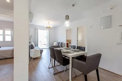 a dining room and living room with a table and chairs at Valencia Flat Rental Malvarrosa Beach zone in Valencia