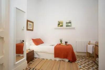 a small bedroom with a bed and a table at SingularStays Ms Rogers in Valencia