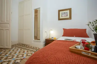 a bedroom with a bed and a table with a mirror at SingularStays Ms Rogers in Valencia