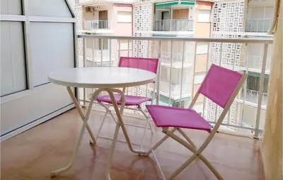 two purple chairs and a table on a balcony at 1 Bedroom Nice Apartment In Cullera in Cullera