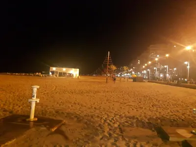a sandy beach at night with lights on it at Apartamento Justina in Cullera