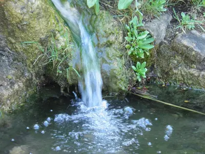 a small waterfall on the side of a pool of water at Casa Rural La Torreta in Corbera de Alcira