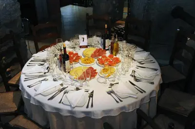 a table with plates of fruit and wine bottles and glasses at Hotel Restaurant Verdià in Sueras