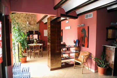 a room with pink walls and a table and chairs at Hotel Restaurant Verdià in Sueras