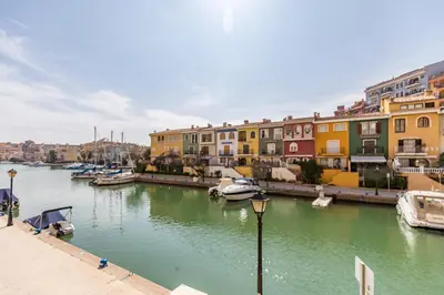 a river with boats in a city with buildings at Beach Apartment with beautiful view in Port Saplaya