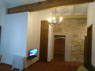 a living room with a chandelier and a television at Casa Rural La Tia Rosa in Chulilla