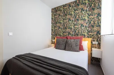 a bedroom with a bed and a desk and a painting at FLORIT FLATS - Stylish 2 Bedroom AC Wifi Terrace Attic in Valencia Center in Valencia