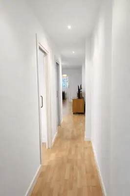 an empty hallway with white walls and wooden floors at FLORIT FLATS - The Jardines del Turia Apartment in Valencia