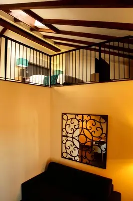 a living room with a black couch and a balcony at Hotel Spa Martín el Humano in Segorbe