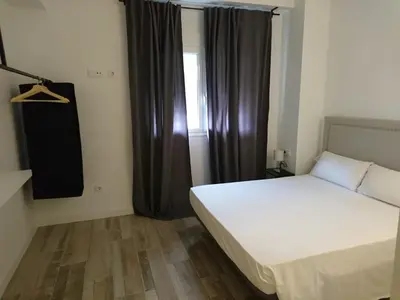 a bedroom with a white bed and a window at NWT Central Station Apartments in Valencia