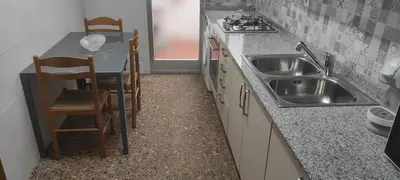 a kitchen with a sink and a table and chairs at playa y relax valencia in Puerto de Sagunto