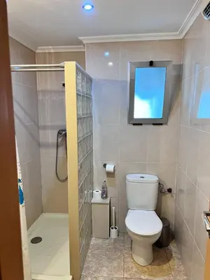 a bathroom with a toilet and a television on the wall at Plaza Sainetero Arniches in Valencia