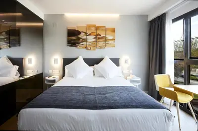 a hotel room with a large bed and a desk at Sercotel Valencia Alameda 41 in Valencia