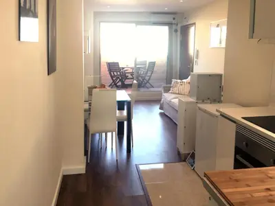 a kitchen and living room with a table and a couch at Ático cerca del mar in Valencia