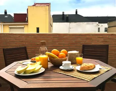 a wooden table with a bowl of fruit and orange juice at Ático cerca del mar in Valencia