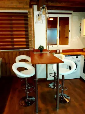 a kitchen with a table and white stools in it at Preciosa Casita Cerca Del Mar in Valencia