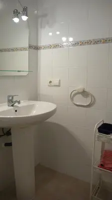 a white bathroom with a sink and a mirror at Apartamento Portalet 7 in Benaguacil