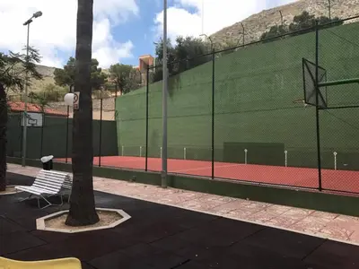 a tennis court with two benches and a fence at Apartamento Florazar 2, 8ºC in Cullera