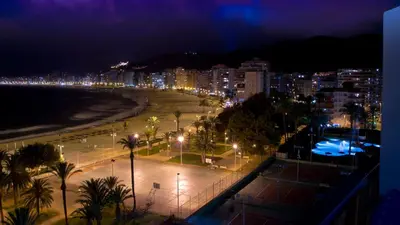 a view of a beach at night with lights at Apartamento Florazar 2, 8ºC in Cullera