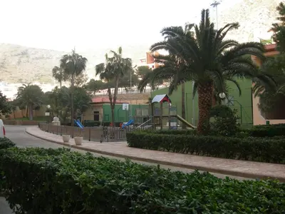 a street with a palm tree and a playground at Apartamento Florazar 2, 8ºC in Cullera