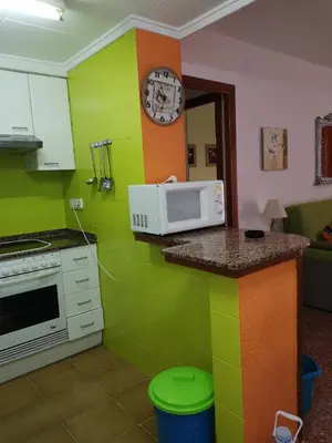 a kitchen with green walls and a microwave on a counter at Apartamento Florazar 2, 8ºC in Cullera