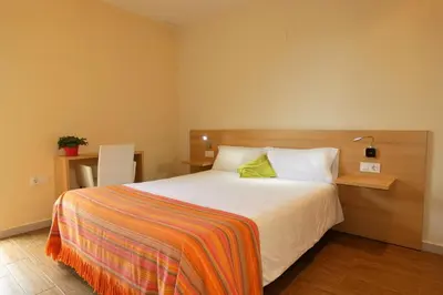 a bedroom with a bed with a colorful blanket on it at Hotel de Montaña La Rocha in Quesa