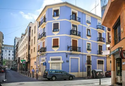 a blue building with a car parked in front of it at Penthouse in historic center in Valencia