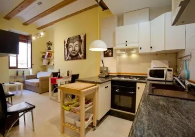 a kitchen with white cabinets and a living room at Apartament in historic center in Valencia