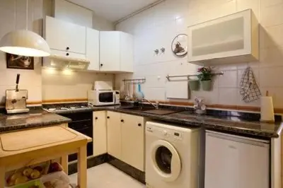 a kitchen with a washing machine in the middle at Apartament in historic center in Valencia