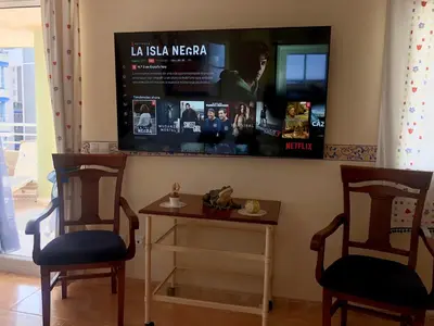 two chairs and a table with a tv on the wall at Retiro Playa y Spa in Tavernes de Valldigna
