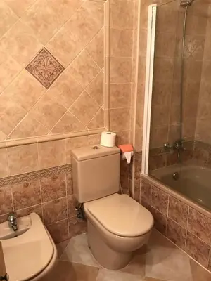 a bathroom with a toilet and a sink and a tub at Retiro Playa y Spa in Tavernes de Valldigna