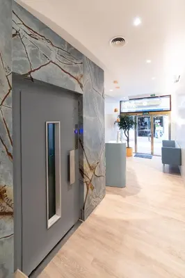 a lobby with a stone wall and a door at Hotel Alkazar in Valencia