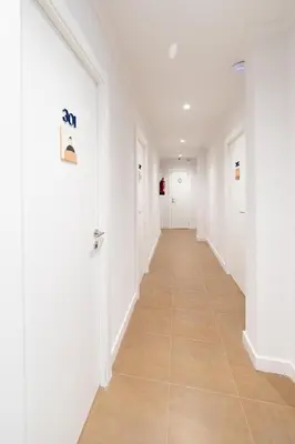 a hallway with white walls and a tile floor at Hotel Alkazar in Valencia